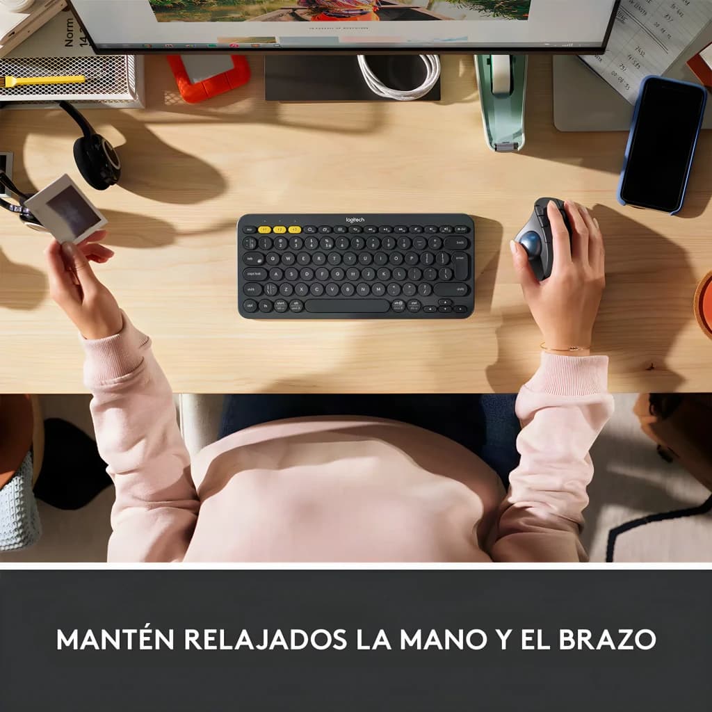 Logitech Ratón ERGO M575S Grafito, vista cenital: mano sujetando el ratón trackball en escritorio junto a teclado Logitech