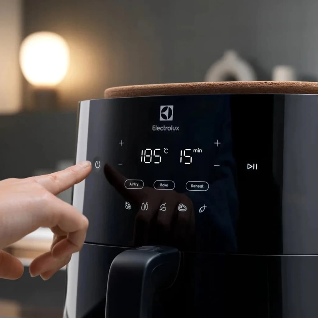 Electrolux Fritadeira de ar EAF7B 6,8L 1800W preto, detalhe painel: ecrã tátil com 185°C e 15 min, mão a pressionar botão