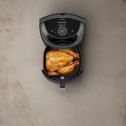 Philips Airfryer Serie 3000 7,2 l Negro Cobre, vista cenital: pollo entero asado en la cesta abierta sobre superficie mármol
