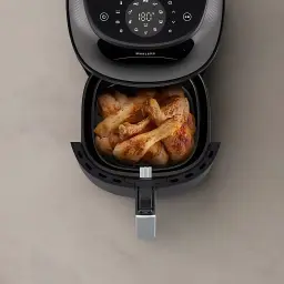 Philips Airfryer Serie 3000 7,2 l Negro Cobre, vista cenital: cesta abierta con alitas de pollo doradas y panel táctil