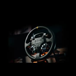 MOZA Racing CS Pro Steering Wheel preto, vista frontal: painel central em carbono, botões RGB e detalhes laranja em ambiente