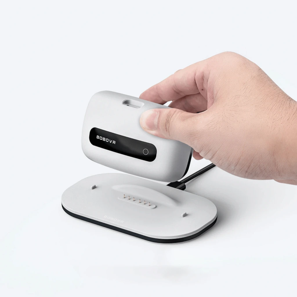 BoboVR M3 Pro+: base de carregamento magnética com conector pogo e módulo branco compacto com display preto, design minimalista e cabo USB traseiro