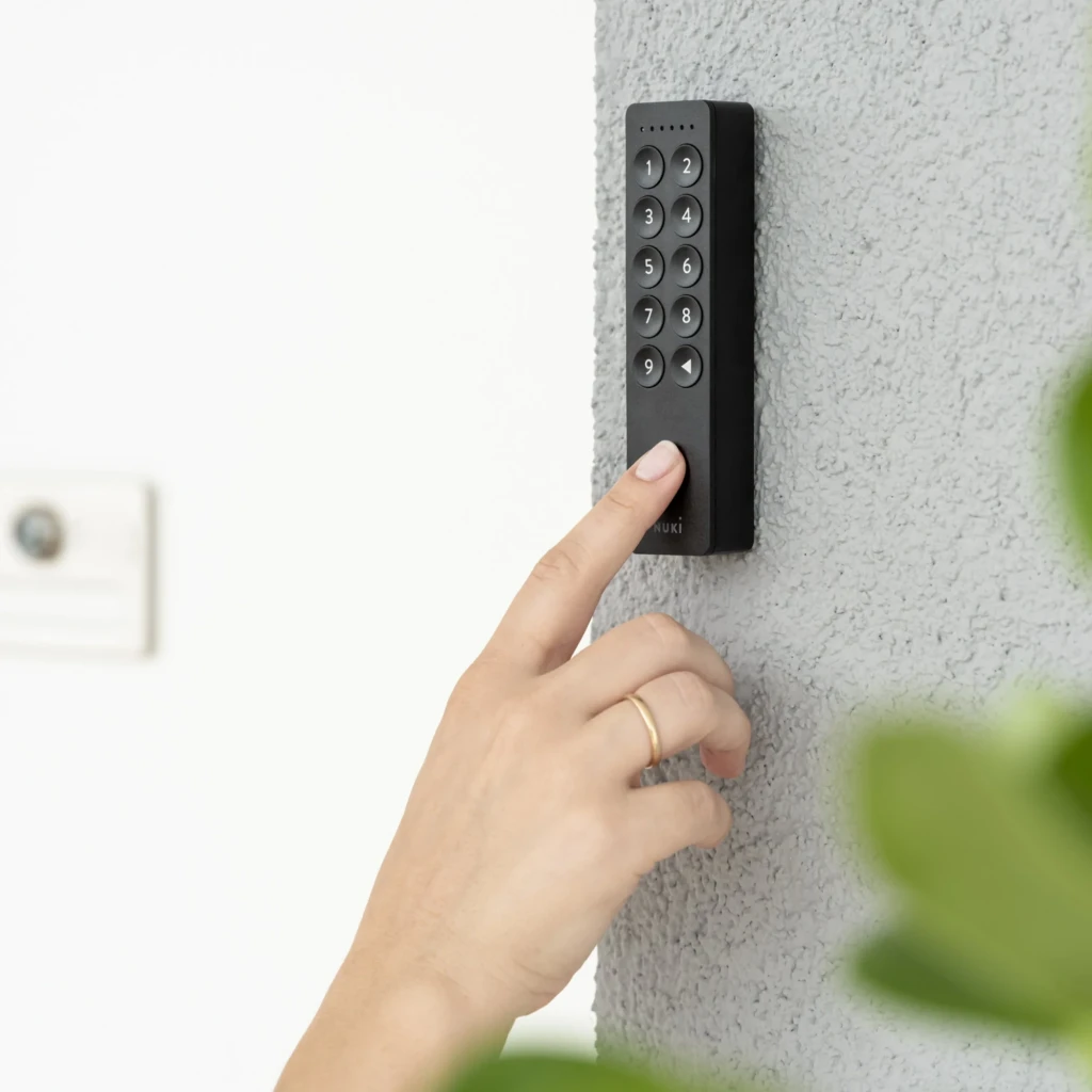 Teclado Nuki Keypad 2.0 Bluetooth preto, numérico com 10 teclas em relevo e LEDs superiores, fixado na parede; uso com um toque para acesso seguro
