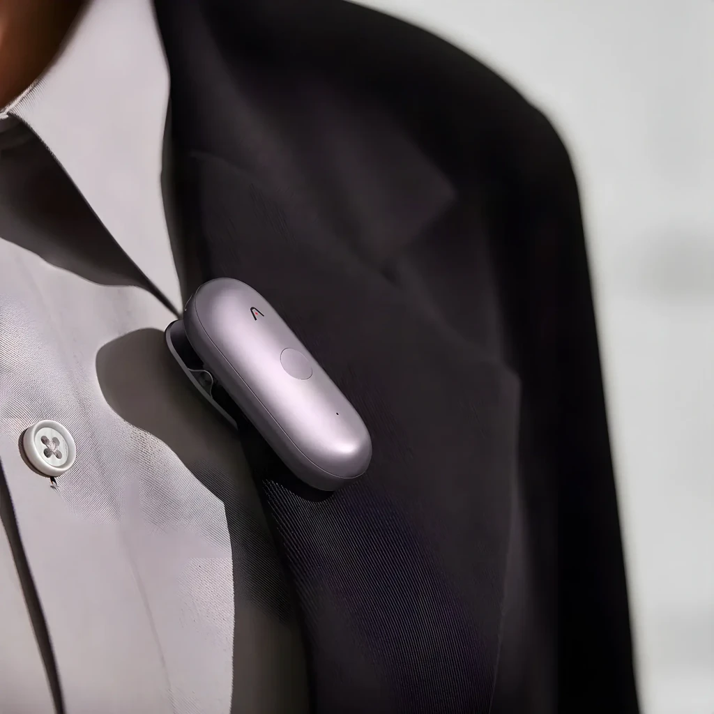 Plaud NotePin S Roxo 64GB, uso: gravador clip preso à lapela de casaco preto, vista frontal com botão central