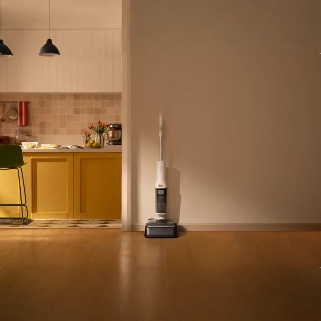 Roborock F25 RT 2,5Ah blanco, vista lateral en hogar: aspiradora apoyada en pared junto a cocina con suelo de madera