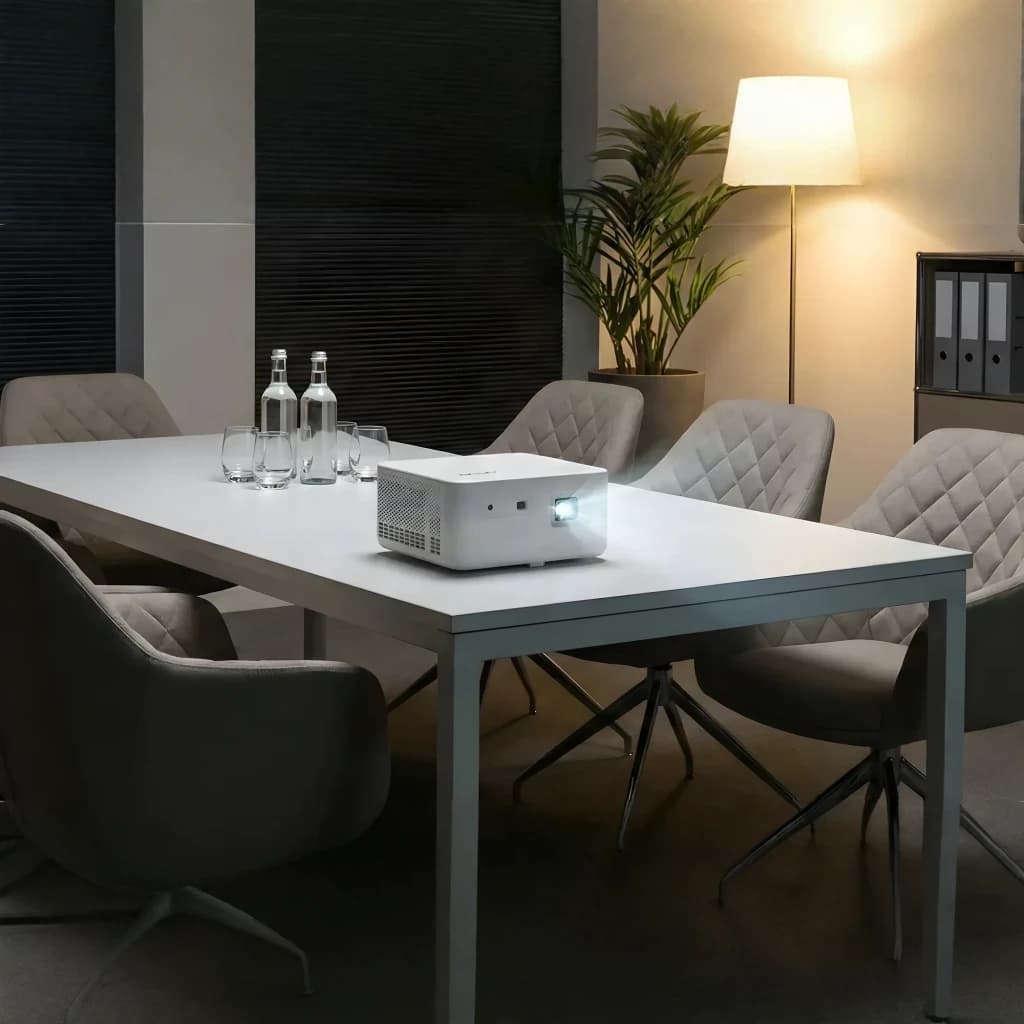 Acer Projecteur PD1810IC 4K UHD RGB-LED Blanc, vue en salle: sur table de réunion avec chaises et objectif allumé