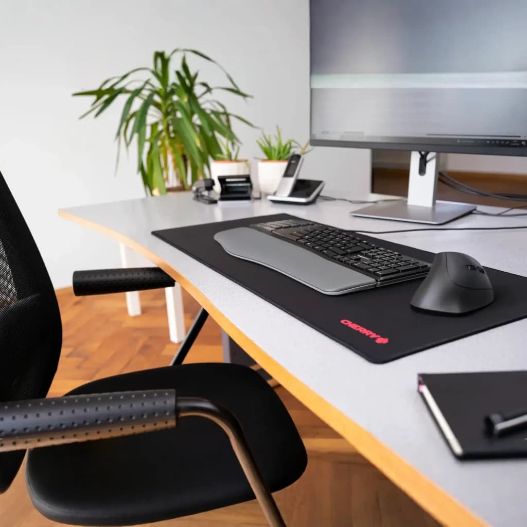 CHERRY KC 4500 ERGO USB QWERTY negro, escena: teclado ergonómico sobre alfombrilla en escritorio de oficina con ratón