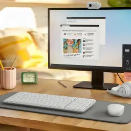 Logitech MK250 Combo QWERTY Espagnol Blanc, scène: clavier et souris blancs sur tapis gris sur bureau en bois avec moniteur