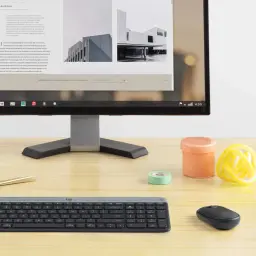 Logitech Teclado e rato sem fio MK470 Slim Combo grafite, vista lifestyle: conjunto sobre secretária de madeira com monitor