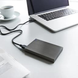 Intenso Memory Board 2TB gris, utilisation: disque connecté en USB à un ordinateur portable sur bureau blanc avec LED bleue