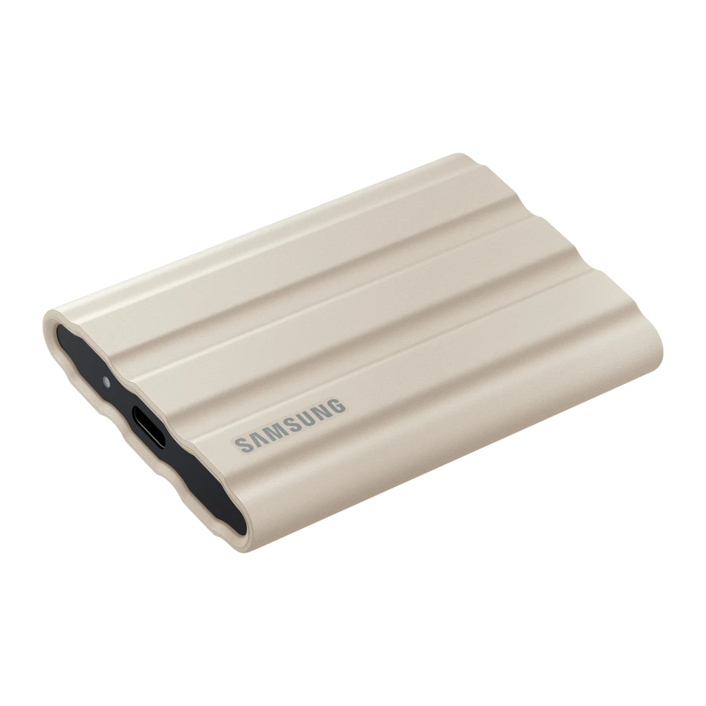 Samsung T7 Shield 2TB Beige, vue avant en angle: coque rainurée beige avec bords noirs et port USB-C visible - Ítem3