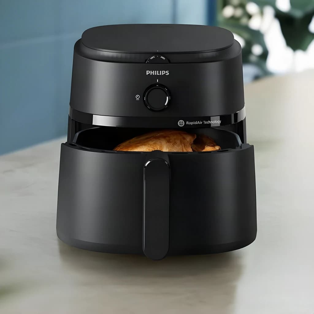 Philips Airfryer Serie 1000 NA130/00 6,2 l negro, vista frontal en cocina: cesta abierta con pollo asado dorado