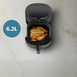 Philips Airfryer Serie 1000 NA130/00 6,2 l Negro, vista superior: cesta abierta con pollo entero asado, superficie mármol