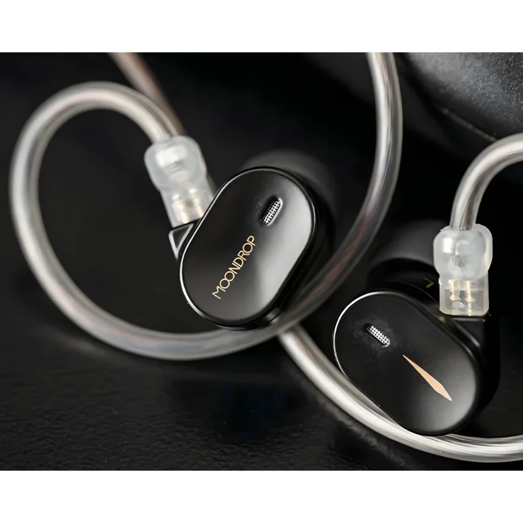 Auriculares Moondrop CHU 3 In‑Ear Jack 3,5 mm sem microfone, cápsulas pretas compactas com detalhe dourado e cabos transparentes sobre a orelha