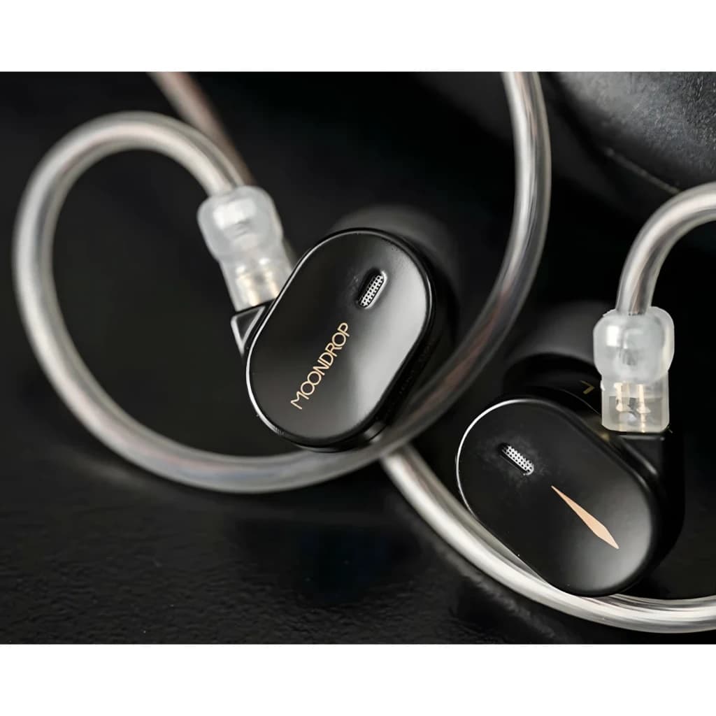 Auriculares Moondrop CHU 3 In‑Ear Jack 3,5 mm sem microfone, cápsulas pretas compactas com detalhe dourado e cabos transparentes sobre a orelha