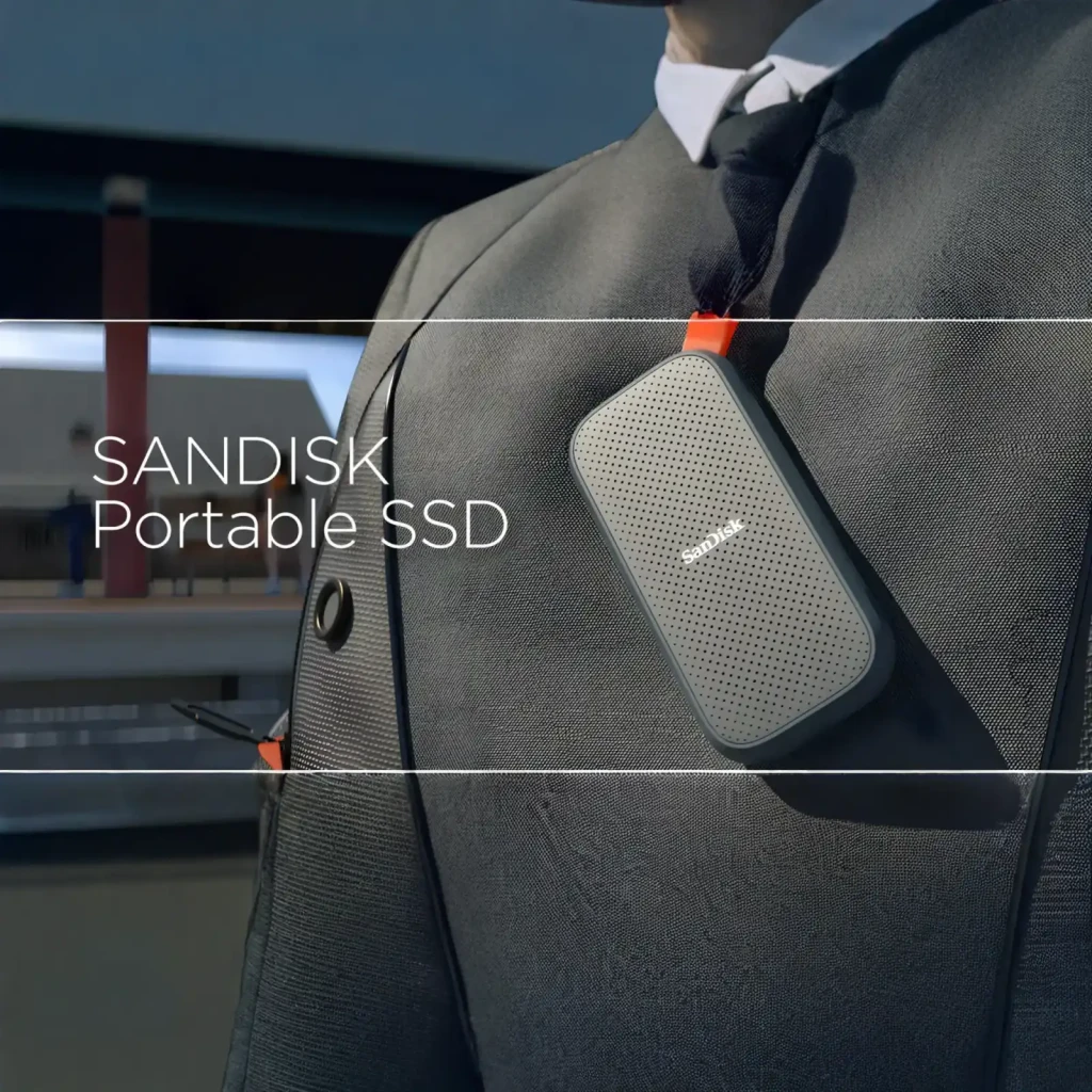 SanDisk SSD Portable V2 2TB preto, vista frontal: superfície texturizada com pontos, logo e alça laranja - Item4