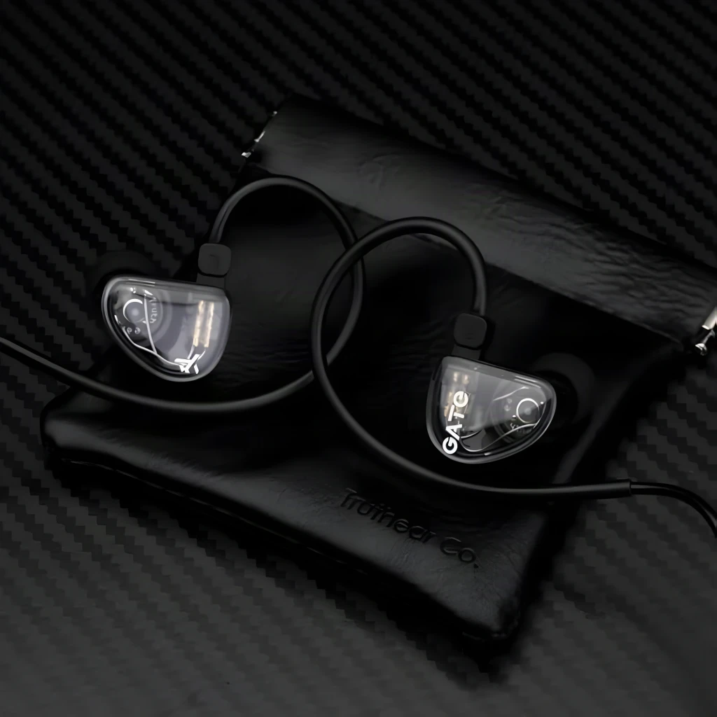 Truthear Gate Auriculares Negro, vista lifestyle: ambos auriculares con carcasa transparente sobre funda Truthear Co.