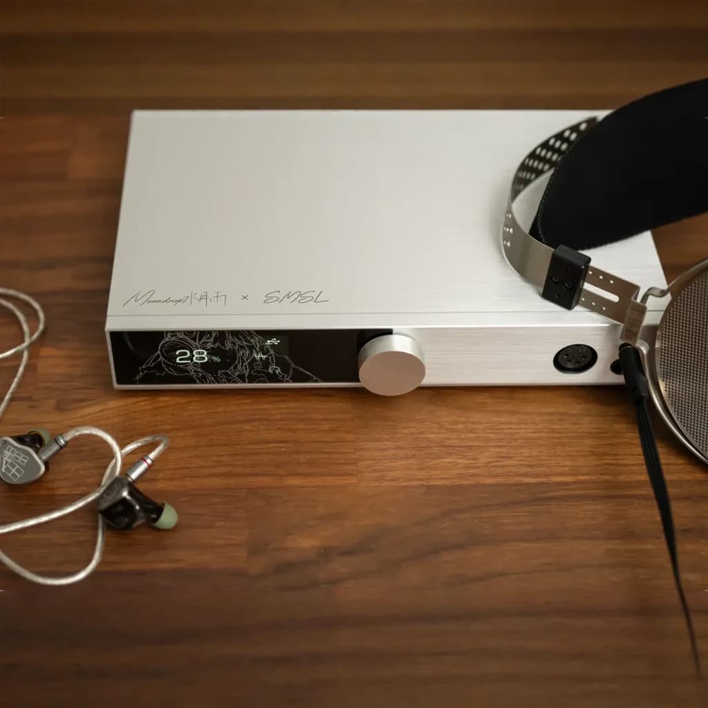 Moondrop DHA15 DAC amplificateur argenté, vue de dessus: panneau avant avec écran, bouton et casque sur bureau en bois