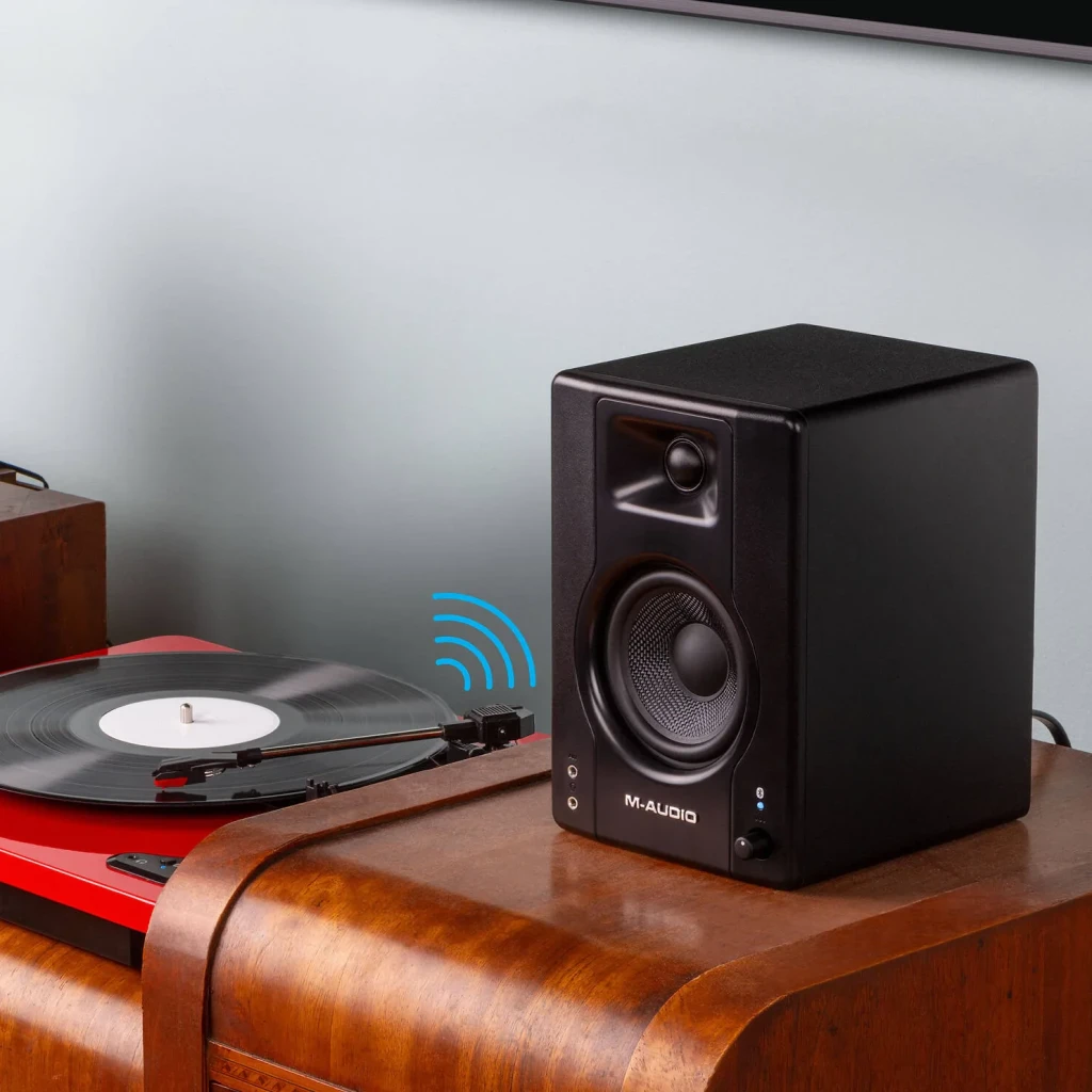 Monitores de Estudio PreSonus Eris 3.5 2nd Gen 50W Bluetooth 5.0, vista frontal lateral: altavoz negro sobre mesa de madera