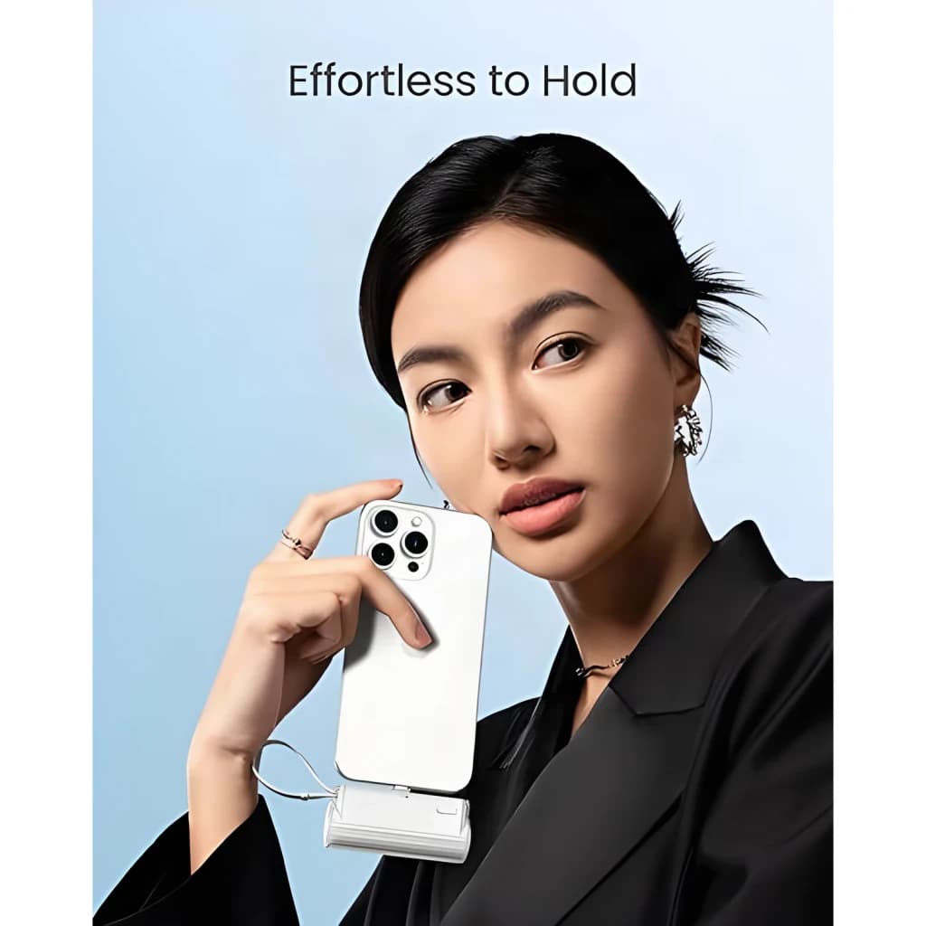 Power Bank Sharge Flow Mini 5000mAh Blue Câble USB-C intégré 22,5W, usage: femme tenant un iPhone avec la batterie suspendue