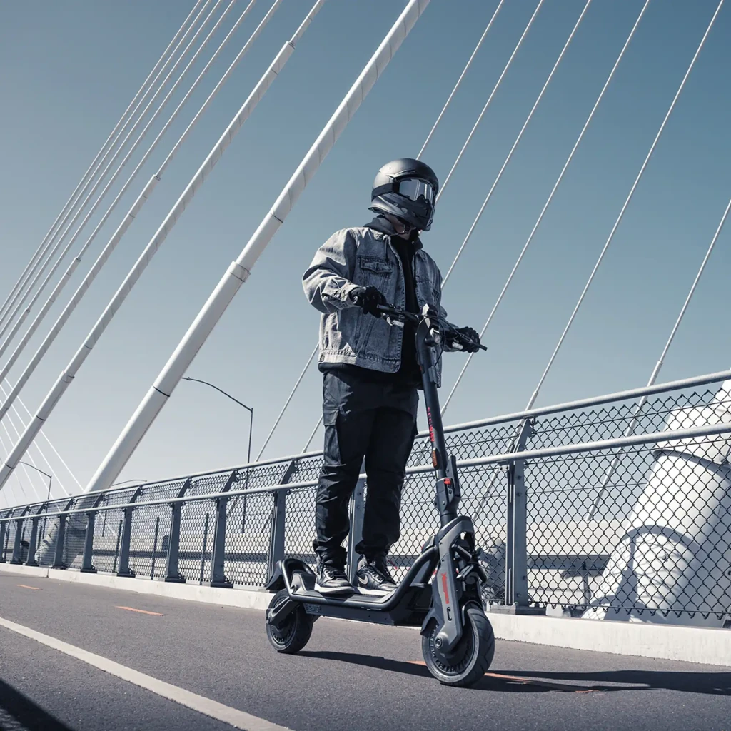 Patinete eléctrico Segway GT3 E 700W 95km 25km/h 11 pulgadas Negro, en uso: rider con casco circulando por puente urbano