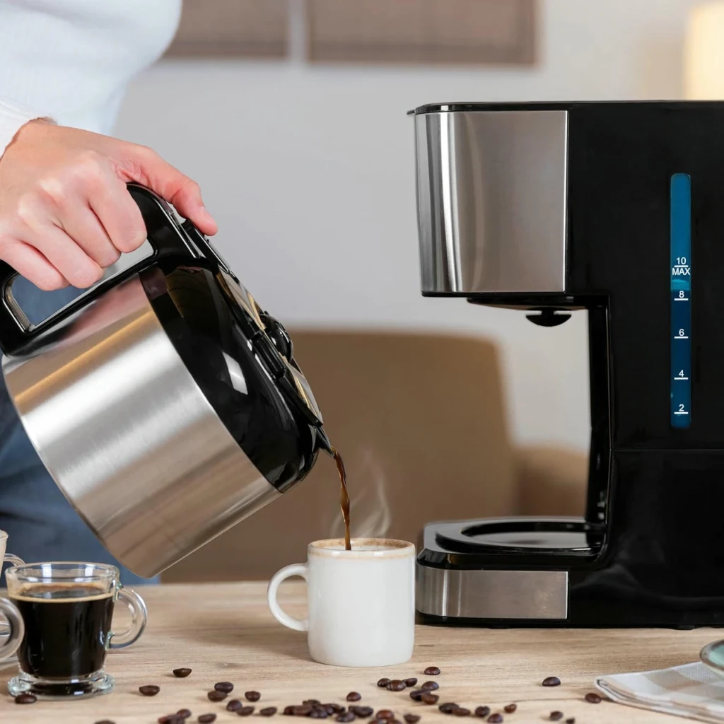 Cafetera de goteo Cecotec Coffee 66 Drop & Thermo Time 1,2L 10 tazas 950W Negro, en uso: mano sirviendo café de la jarra