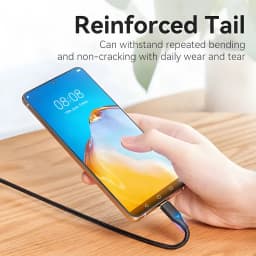 Cable USB Vention TAUB USB-C 2.0 0,5 m 3A a USB-C Negro, en uso: mano conectando el cable trenzado a smartphone sobre mesa
