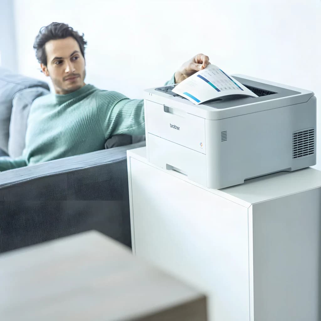 Impressora Brother HL-L3240CDW Laser Cores Duplex Branco, em uso: homem retira página impressa a cores da bandeja de saída