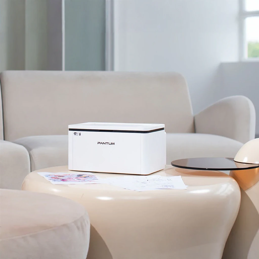 Impresora Pantum BP2300W Láser Monocromo Dúplex Manual Blanco, en uso: sobre mesa de salón junto a documentos impresos