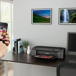 Impressora fotográfica Canon PIXMA PRO-200 A3+ Não multifunções Tinta Preto, em uso: sobre secretária a imprimir foto, mão