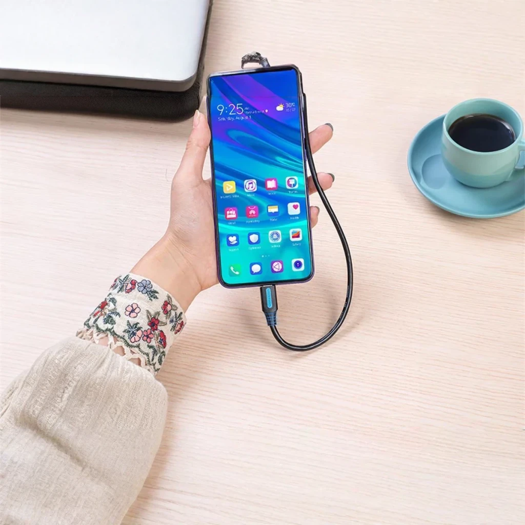 Câble Vention COZBG USB-A vers USB-C 3 A Charge Rapide 1,5 m Noir, en utilisation: main tenant un smartphone avec le câble