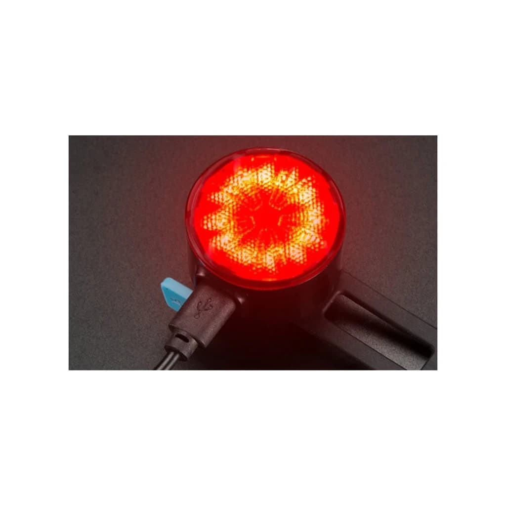 Luz trasera Superfire BTL05 Rojo 4h Micro-USB, en uso: lente circular encendida en rojo intenso con cable Micro-USB conectado