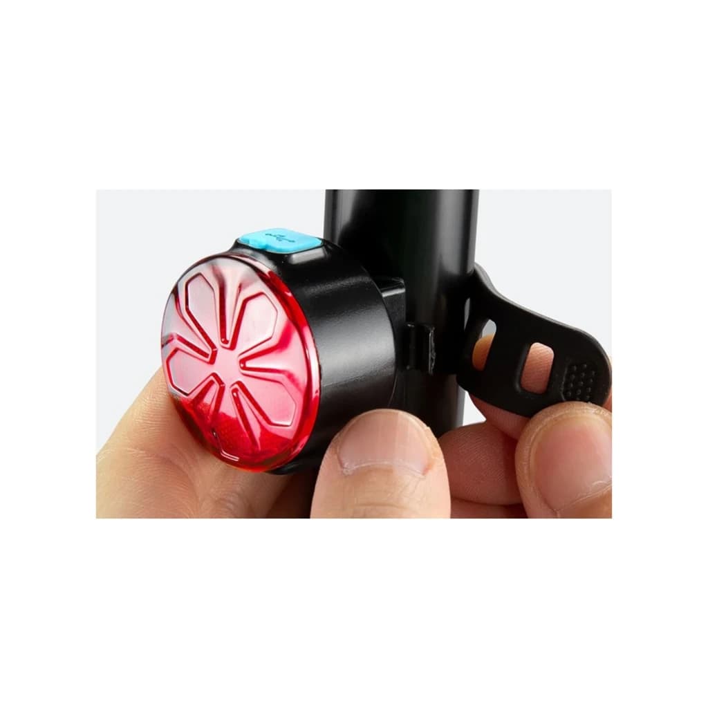 Luz trasera Superfire BTL05 Rojo 4h Micro-USB, en uso: mano sujeta la luz montada en tija, lente roja con patrón floral