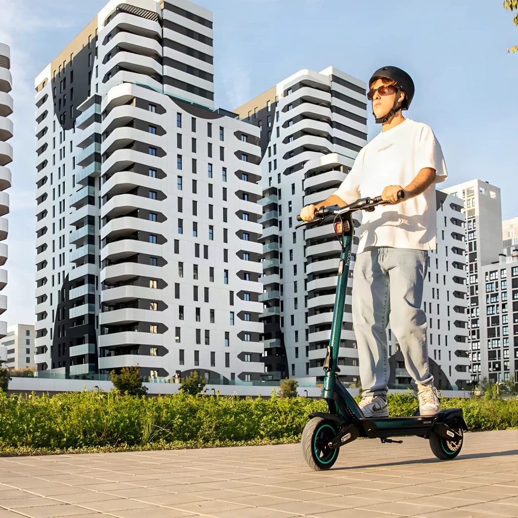 Patinete Eléctrico Cecotec Bongo Y65 Connected 500W 65km 25km/h 10 pulgadas Negro/Verde Azulado, en uso: joven con casco
