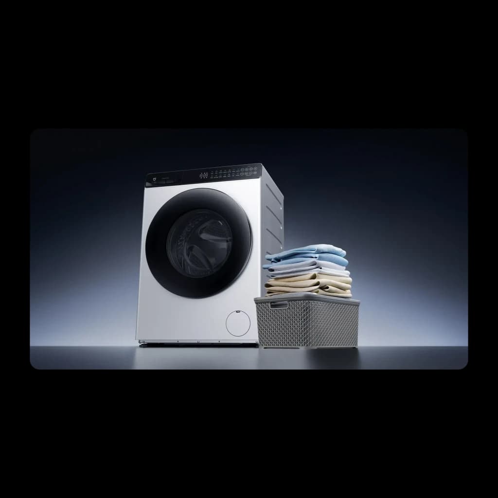 Lavadora-secadora Xiaomi Blanco QMP4656EU, vista frontal: cesta con ropa doblada junto a la máquina sobre superficie gris