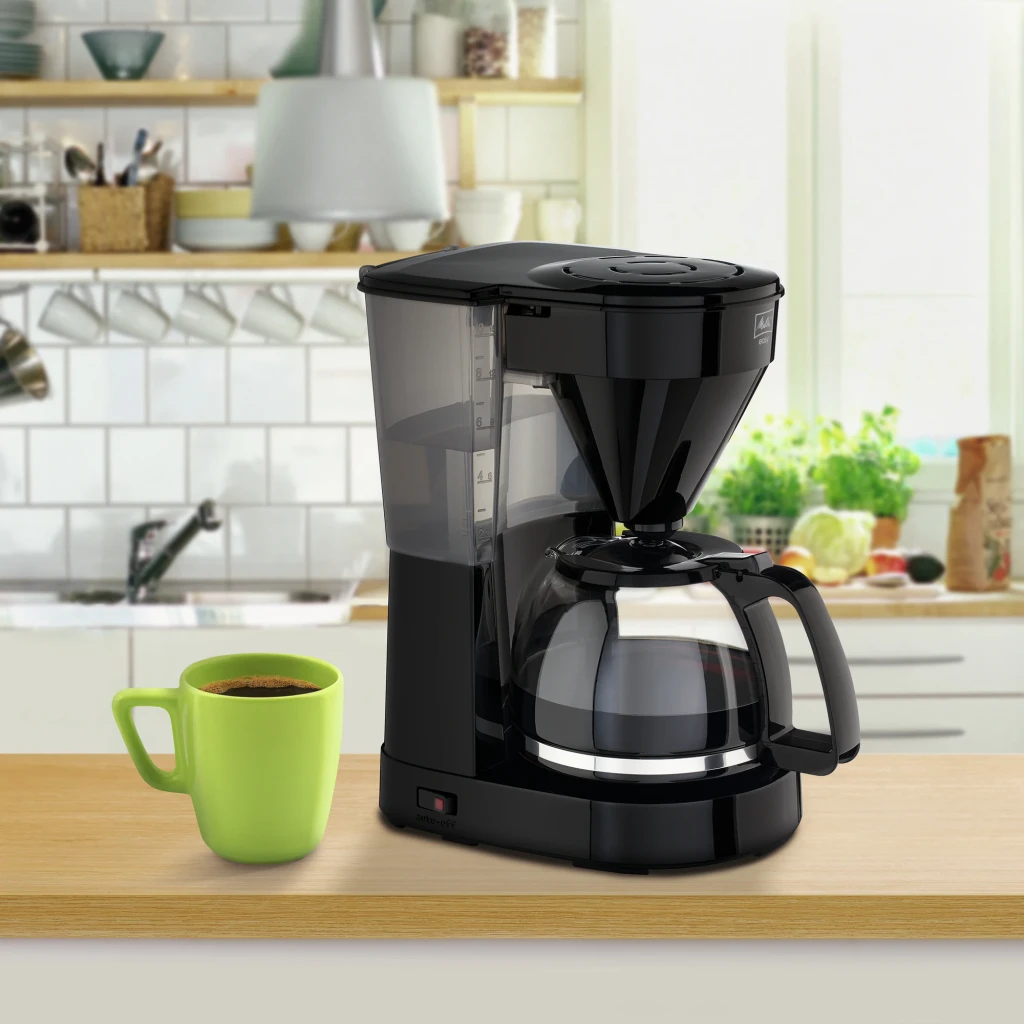 Cafetière filtre Melitta Easy 1023-02 10 tasses 1050W Noir, en utilisation: sur plan de cuisine avec tasse verte de café
