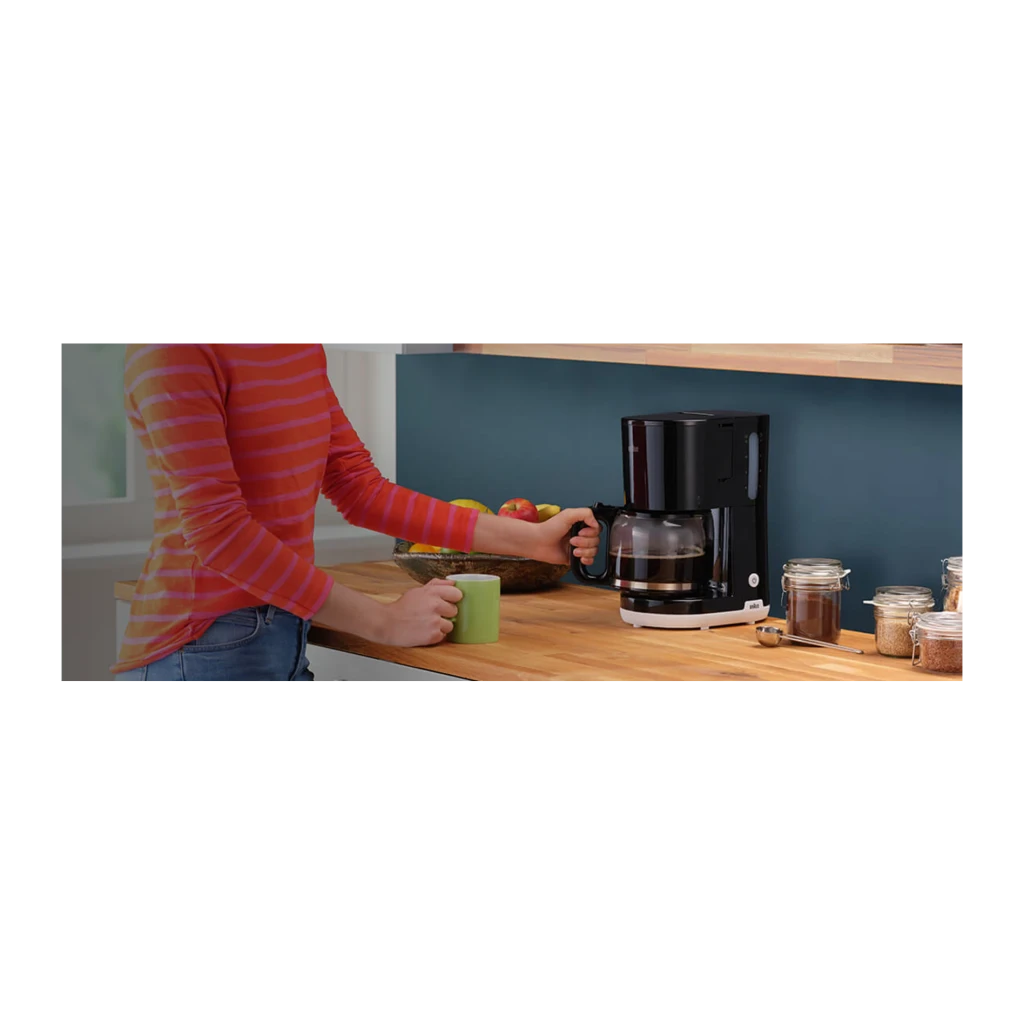 Cafeteira de filtro Braun KF1100 Jarro 10 Chávenas 1000W Preto, em uso: pessoa a retirar o jarro numa bancada de cozinha