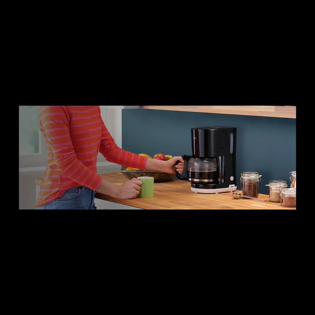 Cafeteira de filtro Braun KF1100 Jarro 10 Chávenas 1000W Preto, em uso: pessoa a retirar o jarro numa bancada de cozinha