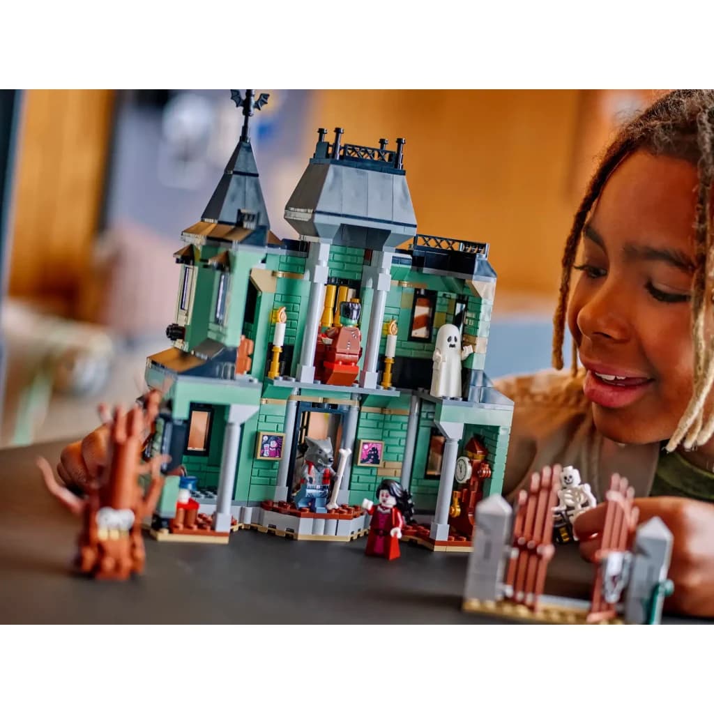 Set de construction LEGO Creator Manoir Hanté 31167 736 pièces 9+ ans, en jeu: fillette souriante joue avec le manoir vert