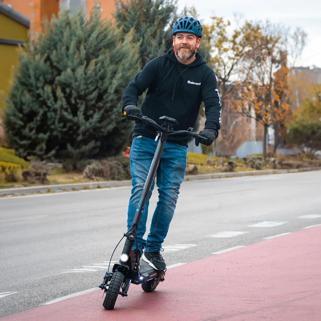 Patinete eléctrico smartGyro CrossOver Dual Max 2 LR 1000W 60km 25km/h 10 pulgadas Negro, en uso: hombre con casco