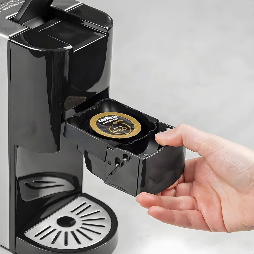 Cafetière à capsules Princess 0,8L 19bar 1450W Argent 249451, en cours d'utilisation: main insérant une capsule Lavazza
