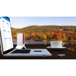 Router AVM FRITZ!Box 6820 LTE Branco Wi-Fi 4 2,4GHz 450Mbps Banda única, cena: sobre mesa de madeira com portátil e chávena