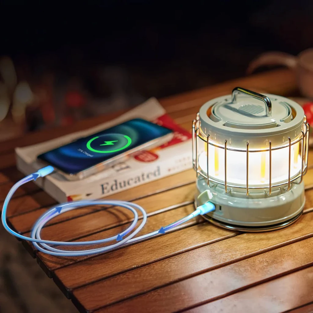 Lámpara de camping Flextail Max Lantern 3 en 1 Verde Recargable USB-C, en uso: cargando smartphone sobre mesa de madera