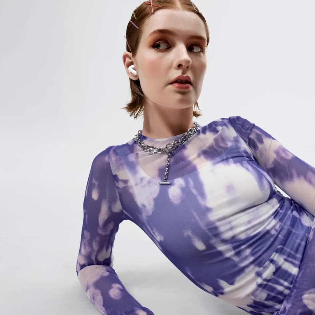 Écouteurs Urbanista Palermo Réduction de Bruit TWS Bluetooth 6.0 Blanc, en utilisation: femme portant un écouteur blanc à