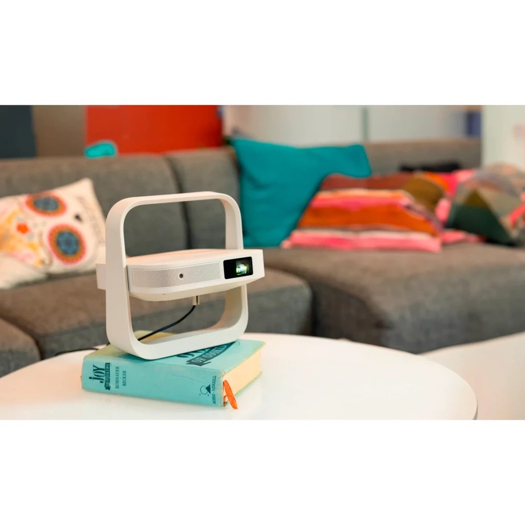 Proyector XGIMI Elfin Flip Plus Full HD 1080p 500 lúmenes ISO LED DLP Google TV Beige, en uso: sobre libros en mesa de salón