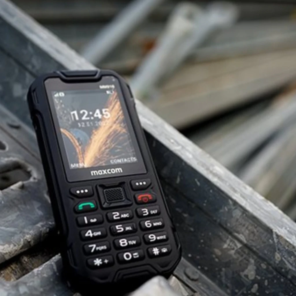 MaxCom Strong MM918 4G VoLTE Preto IP68 2500mAh 2.4 polegadas, em uso: apoiado em vigas metálicas, ecrã ligado com hora