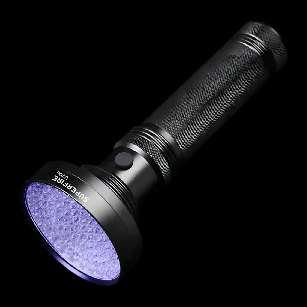 Linterna UV Superfire UV06 Negro 9V, vista frontal: cabezal encendido con LEDs UV violeta, cuerpo estriado y botón lateral
