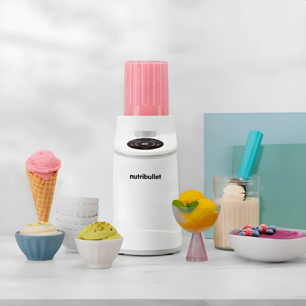 Sorbetière NutriBullet Chill 0,47L 500W Blanc NBD0503W, en utilisation: entourée de glaces en cornet, bols et smoothies