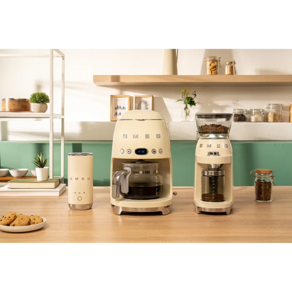 Cafetière filtre SMEG 50's Style 1,4L 1050W Crème DCF02CREU, en utilisation: sur plan de travail bois avec moulin