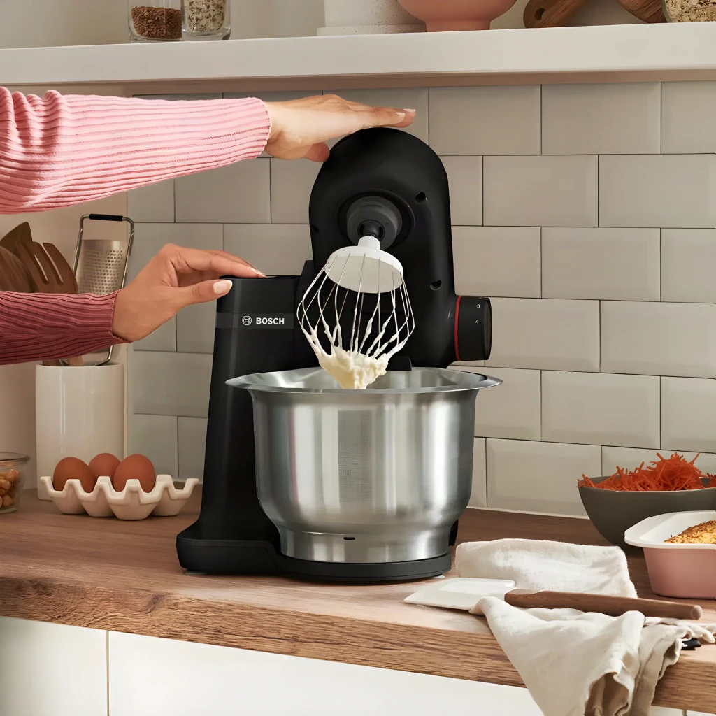Robot de cozinha Bosch MUM Serie 2 3,8L 700W 4 Velocidades Preto MUMS2EB01, em uso: mãos ajustando o batedor com massa